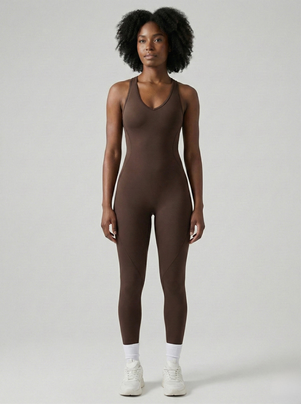 Person wearing a brown bodysuit on a plain background