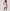 Woman wearing a pink tennis outfit on a white background